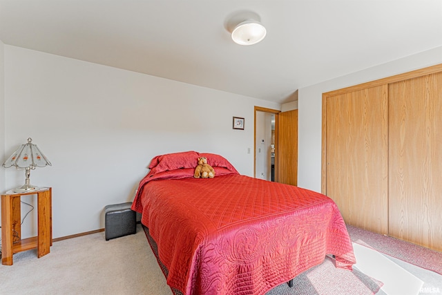 bedroom with light carpet, a closet, and baseboards