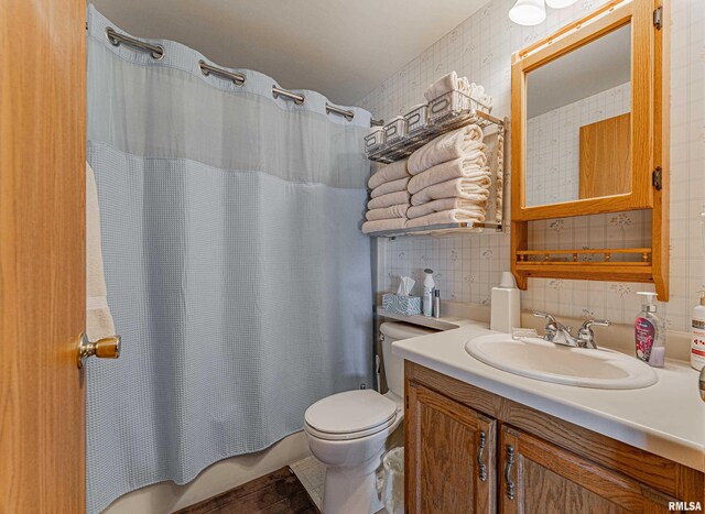 bathroom with decorative backsplash, vanity, toilet, and shower / tub combo with curtain