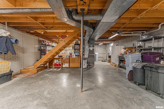 unfinished basement featuring heating unit and brick wall