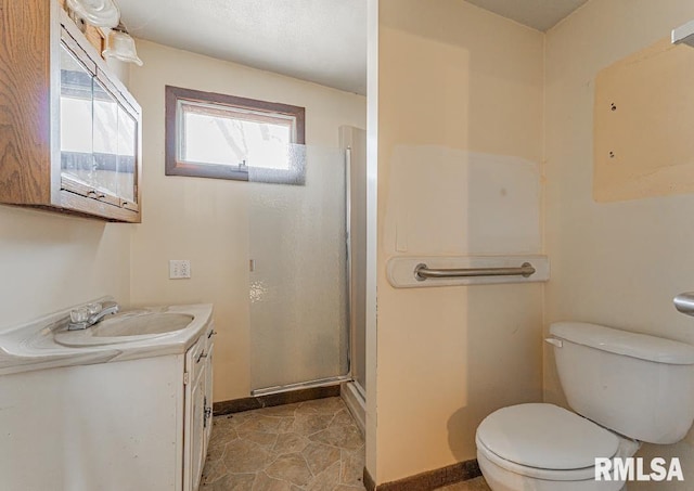 bathroom featuring a stall shower, toilet, vanity, and baseboards