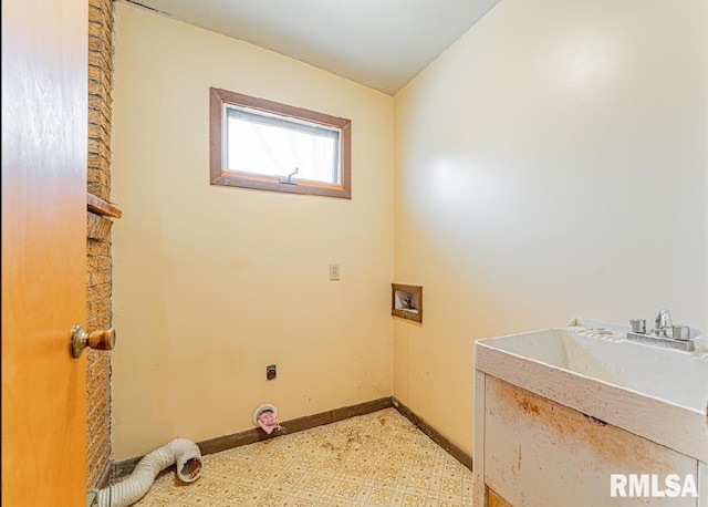 clothes washing area featuring laundry area, hookup for a washing machine, light floors, and baseboards