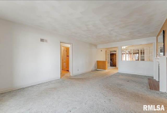 unfurnished living room featuring visible vents, baseboards, and carpet