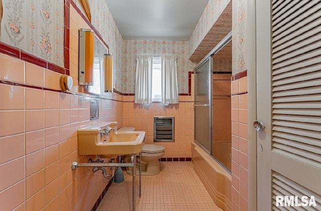 full bathroom with toilet, a sink, wallpapered walls, wainscoting, and tile patterned flooring