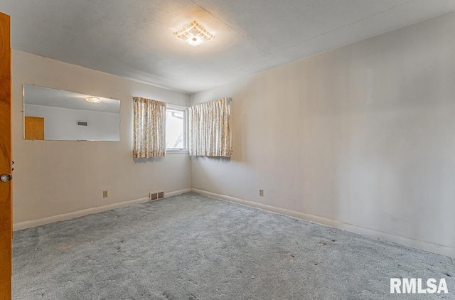 carpeted empty room featuring visible vents and baseboards