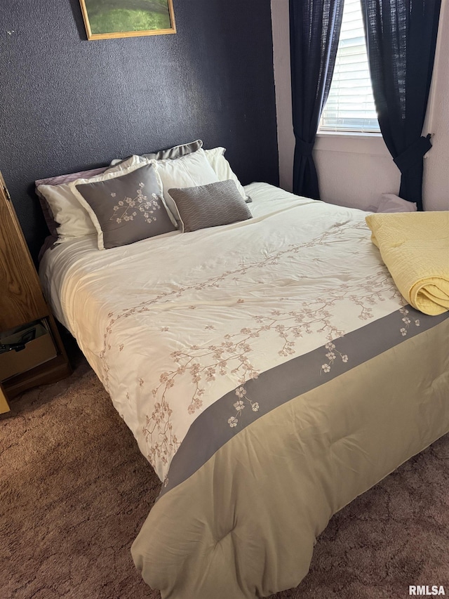 carpeted bedroom featuring a textured wall