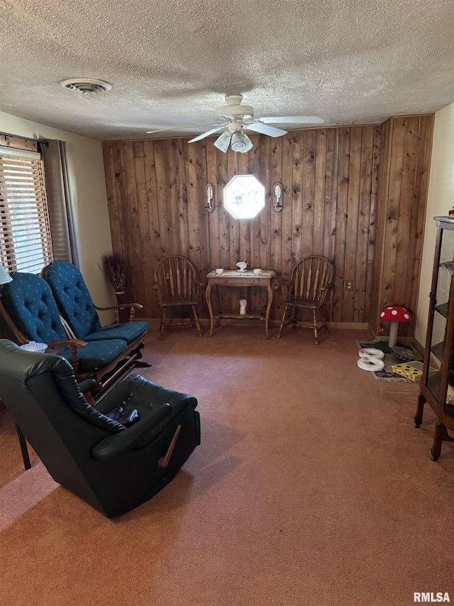 unfurnished room with visible vents, carpet floors, a textured ceiling, and a ceiling fan