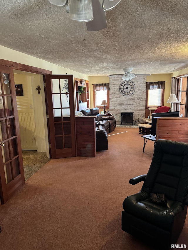 carpeted living area with a fireplace and a textured ceiling