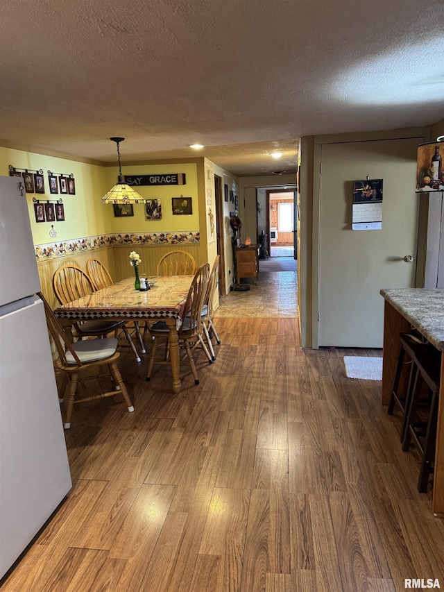 dining space featuring wood finished floors and a textured ceiling