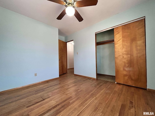 unfurnished bedroom with a closet, baseboards, wood finished floors, and a ceiling fan