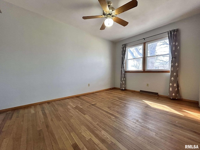 spare room with ceiling fan, visible vents, baseboards, and light wood-style flooring