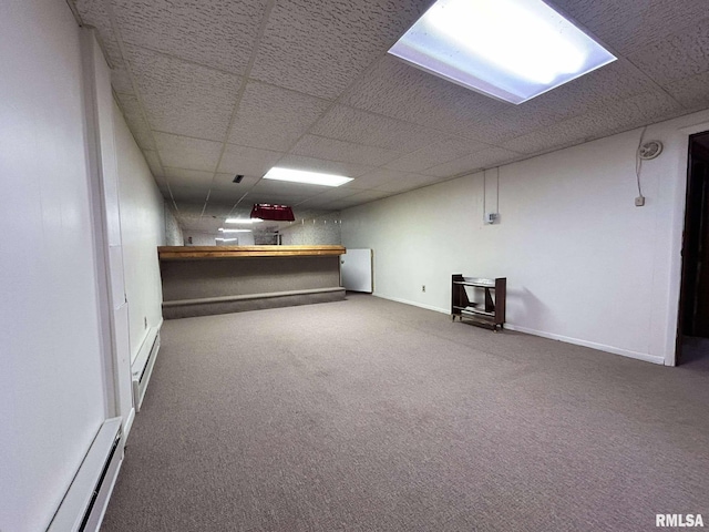 finished below grade area with baseboards, a paneled ceiling, and carpet flooring