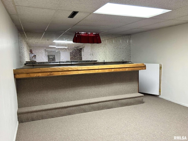 bar featuring a drop ceiling, baseboards, and carpet