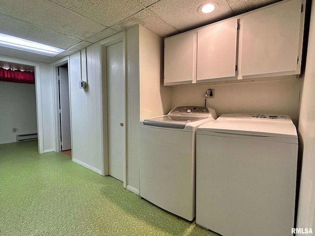 laundry area featuring baseboards, light floors, baseboard heating, cabinet space, and separate washer and dryer