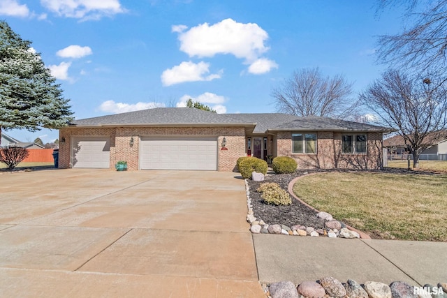 ranch-style home with brick siding, an attached garage, driveway, and a front lawn