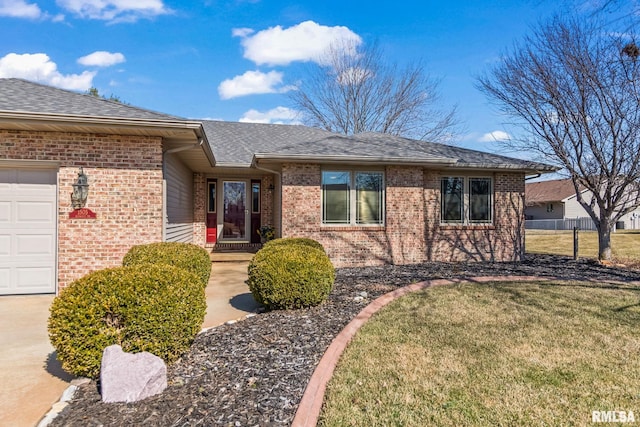 view of front of property featuring a front yard, a garage, brick siding, and roof with shingles