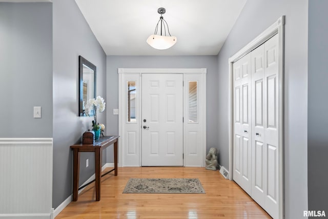 entrance foyer with baseboards and light wood finished floors