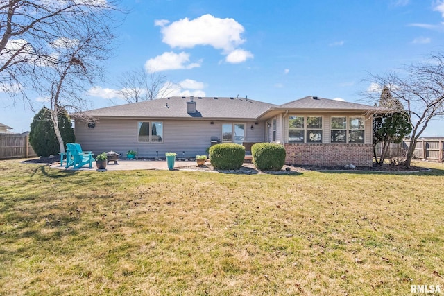 back of property featuring brick siding, a patio area, fence, and a lawn