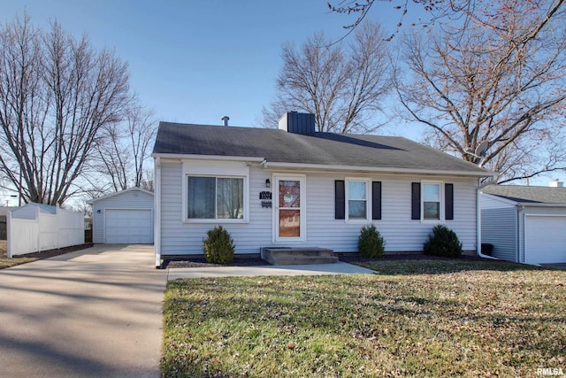 view of front facade featuring an outbuilding, a chimney, concrete driveway, a front lawn, and a garage