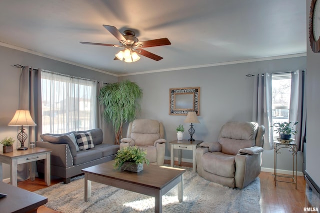 living room with crown molding, plenty of natural light, wood finished floors, and baseboards