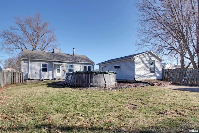 back of house featuring a fenced in pool, a lawn, and a fenced backyard