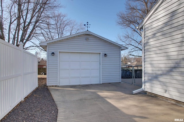 detached garage with fence and driveway