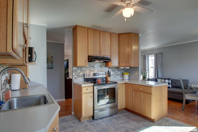 kitchen with a peninsula, stainless steel electric stove, a sink, light countertops, and under cabinet range hood