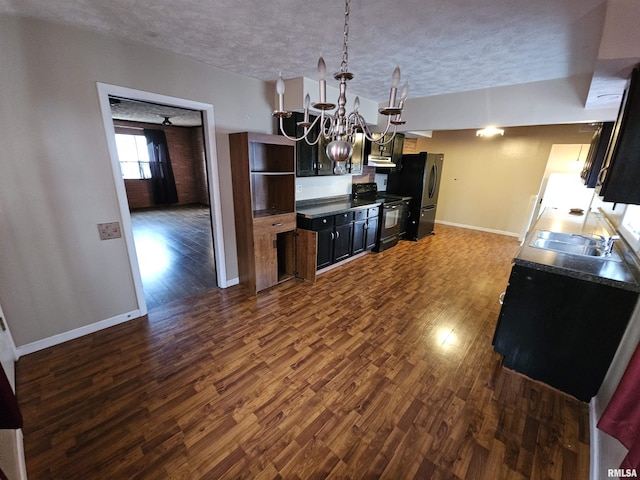 kitchen featuring dark wood finished floors, freestanding refrigerator, black electric range, a notable chandelier, and a sink