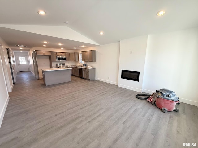 kitchen featuring light wood-style flooring, gray cabinets, open floor plan, stainless steel appliances, and lofted ceiling