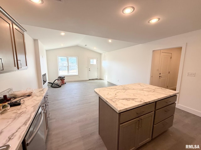 kitchen with a kitchen island, light stone countertops, dishwasher, vaulted ceiling, and recessed lighting