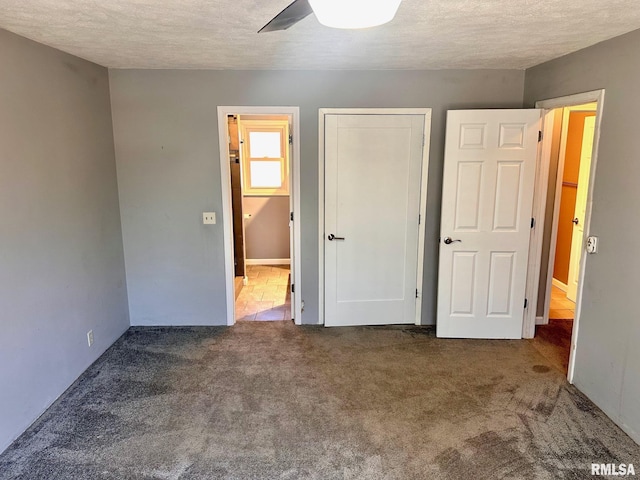 unfurnished bedroom with carpet floors, a textured ceiling, and a ceiling fan