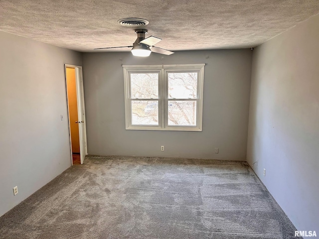 carpeted empty room with a textured ceiling, visible vents, and ceiling fan