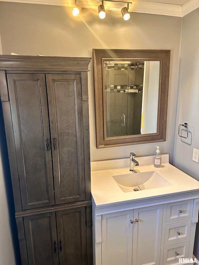 full bathroom featuring vanity, crown molding, and a stall shower