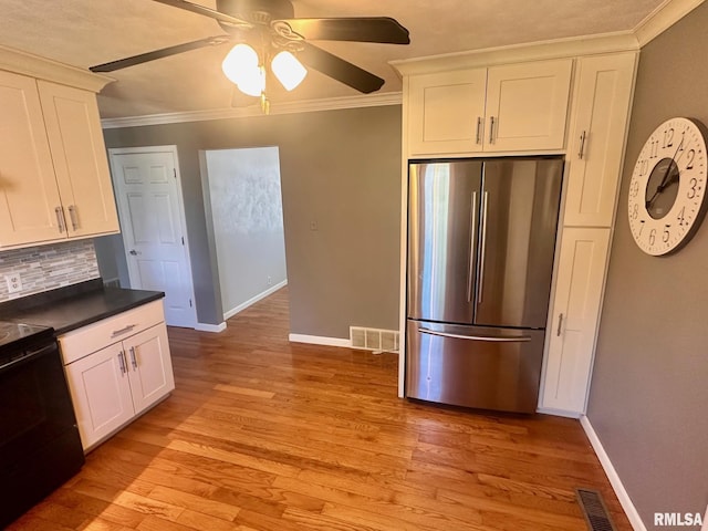 kitchen featuring crown molding, freestanding refrigerator, light wood-style floors, white cabinetry, and black / electric stove