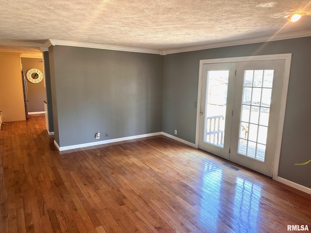 unfurnished room with hardwood / wood-style flooring, crown molding, visible vents, and a textured ceiling