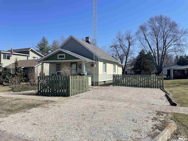 view of front of home featuring a fenced front yard, covered porch, and driveway