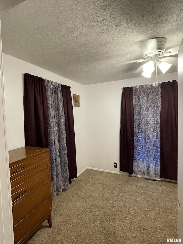 unfurnished bedroom with ceiling fan, a textured ceiling, and carpet