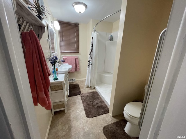 bathroom featuring vanity, toilet, baseboards, and a stall shower