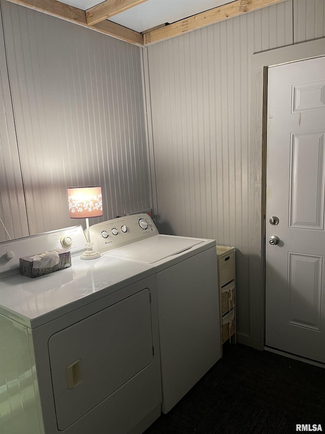 laundry room with laundry area, independent washer and dryer, and wood walls