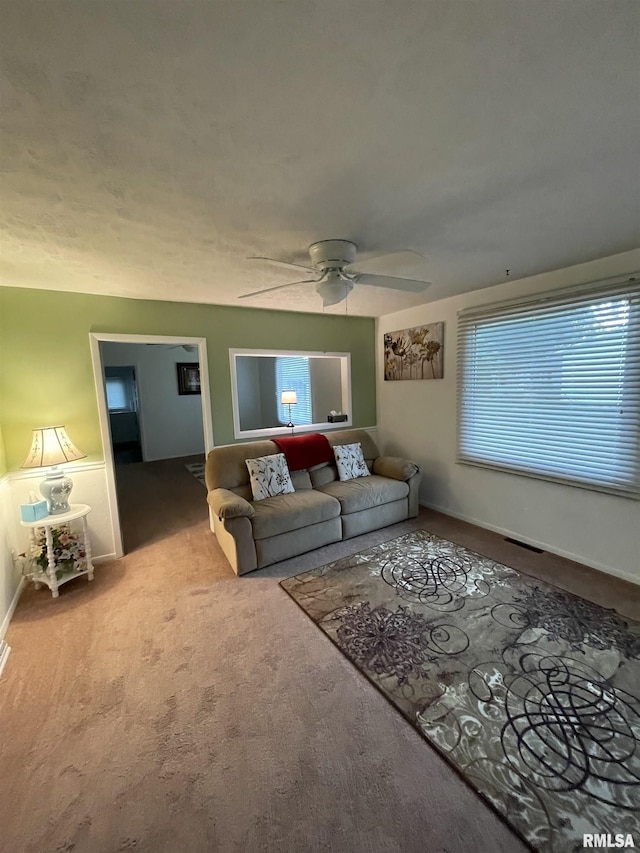 living room featuring a wealth of natural light, a ceiling fan, and carpet floors