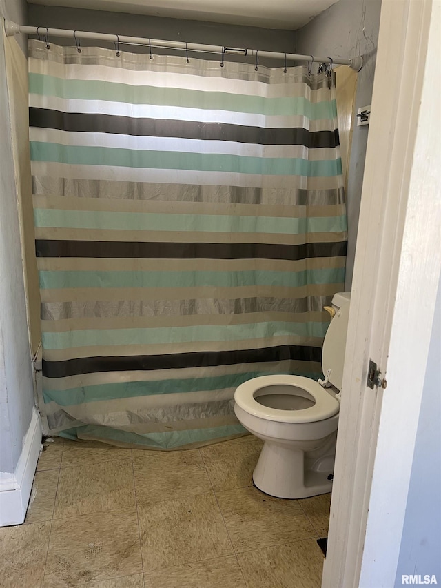 full bathroom featuring curtained shower, tile patterned floors, and toilet