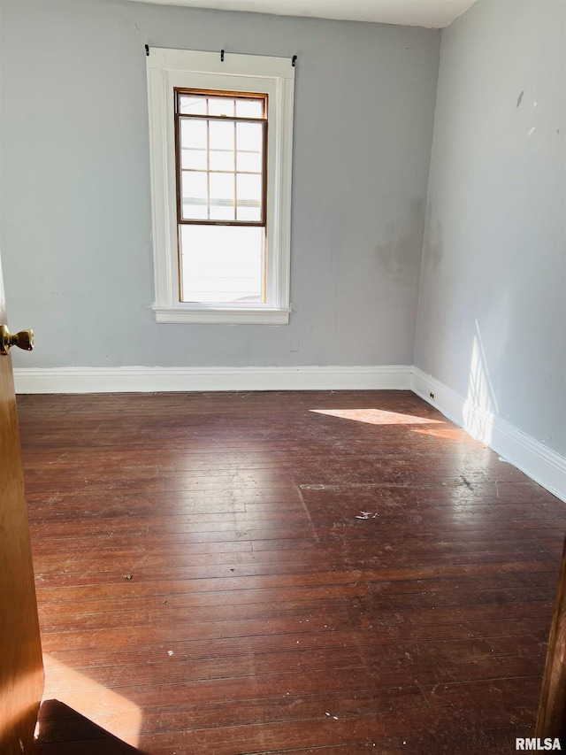 unfurnished room with baseboards and hardwood / wood-style flooring