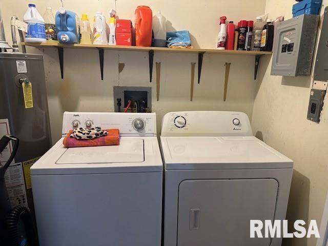 washroom with water heater, laundry area, washer and dryer, and electric panel