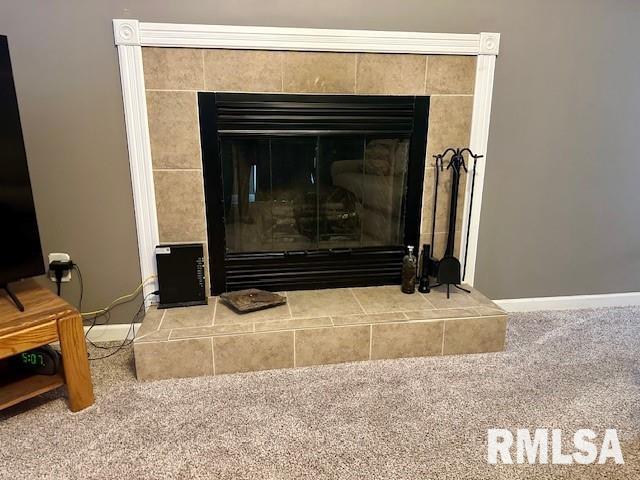 details with baseboards, carpet floors, and a tile fireplace