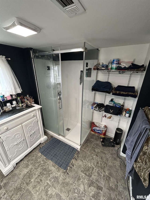 bathroom featuring visible vents, vanity, and a shower stall