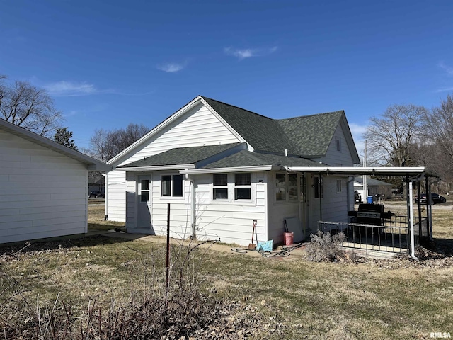 rear view of house with roof with shingles