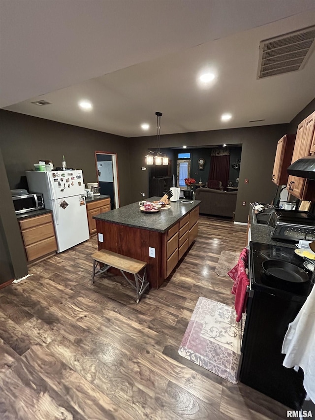 kitchen featuring dark countertops, visible vents, freestanding refrigerator, black electric range oven, and dark wood-style flooring