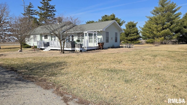 view of front facade with a deck and a front yard