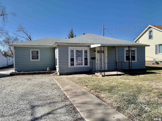 bungalow with covered porch and a front lawn