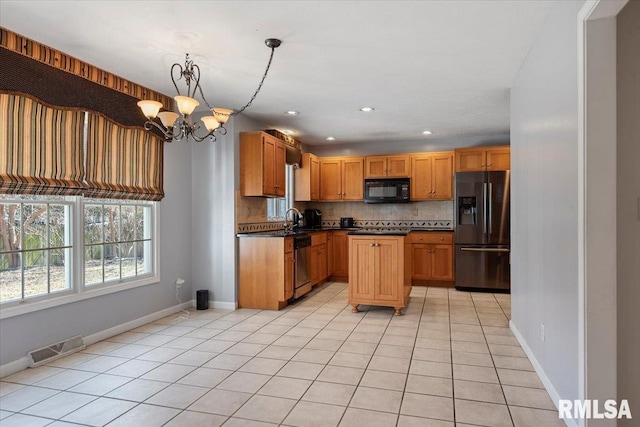 kitchen featuring visible vents, a sink, backsplash, dark countertops, and stainless steel appliances