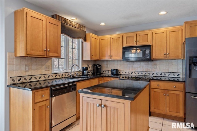 kitchen featuring tasteful backsplash, a center island, light tile patterned floors, black appliances, and a sink